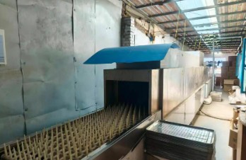 Handmade glass cups being processed in a factory setting at Zibo Bull Glassware Co.,Ltd.