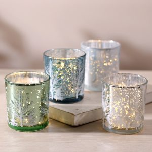 Handmade glass candle holders with festive gold and silver accents.