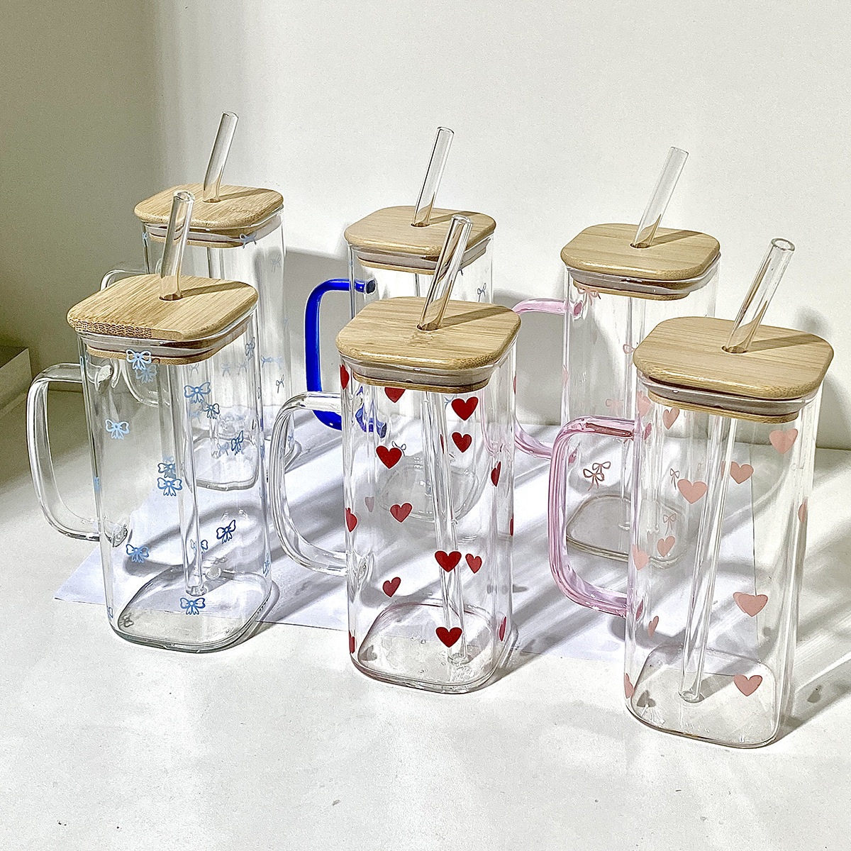 Handmade glass cups with bamboo lids and straws, featuring colorful heart and flower designs. Perfec.