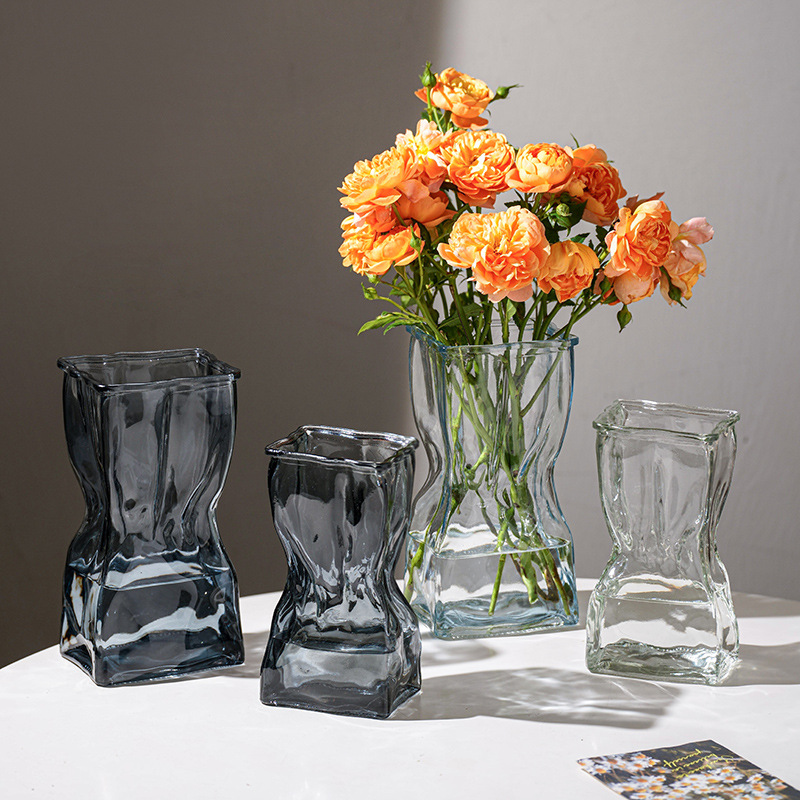 Handmade glass vases with unique wavy design, perfect for floral arrangements.