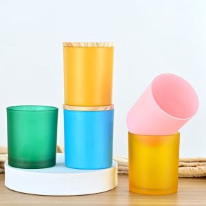 Vibrant handmade glass cups in yellow, green, blue, and pink, perfect for candles or decorative use.